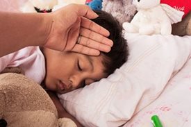 nurturing hand checks for fever on temple of sleeping child