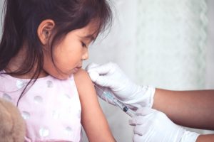 Doctor injecting vaccination in arm of asian little child girl,healthy and medical concept