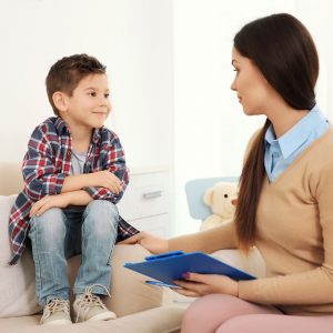 Pediatric clinician sitting with young boy